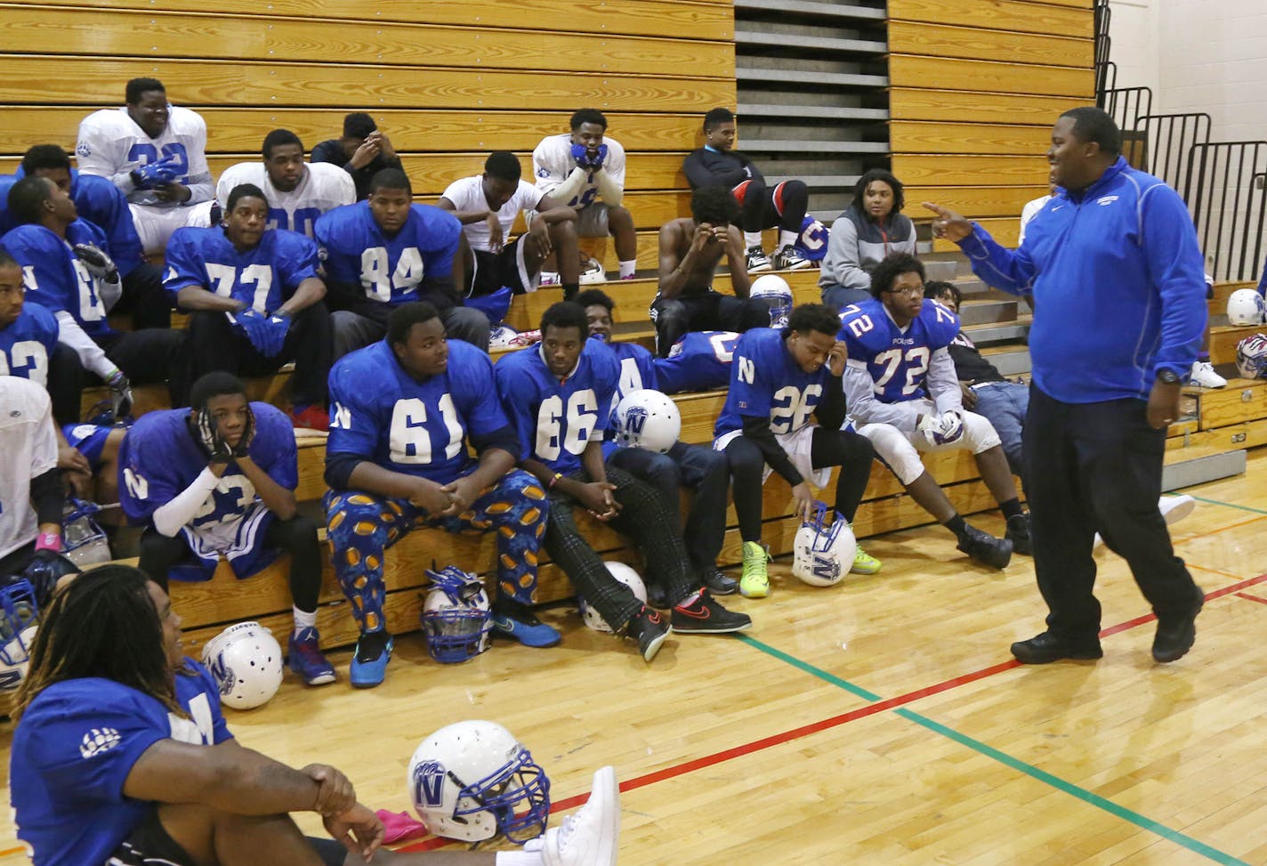 In this photo taken Wednesday, Nov. 12, 2014, North High School head football coach Charles Adams, right, talks to his team after practice in Minneapolis. The Polars lost every game in football in 2011 but hard work, commitment and community pride went a long way as they are now unbeaten in the state semifinals. (AP Photo/Jim Mone)