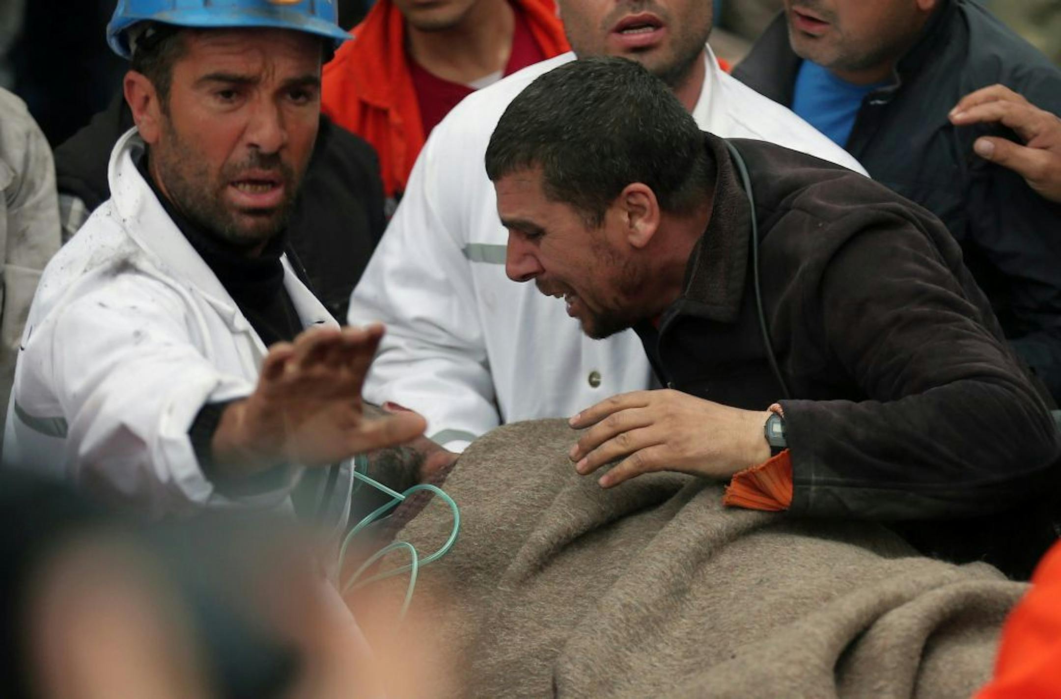 A man reacts as rescue workers carry the body of a miner from the mine in Soma, western Turkey, early Wednesday, May 14, 2014.