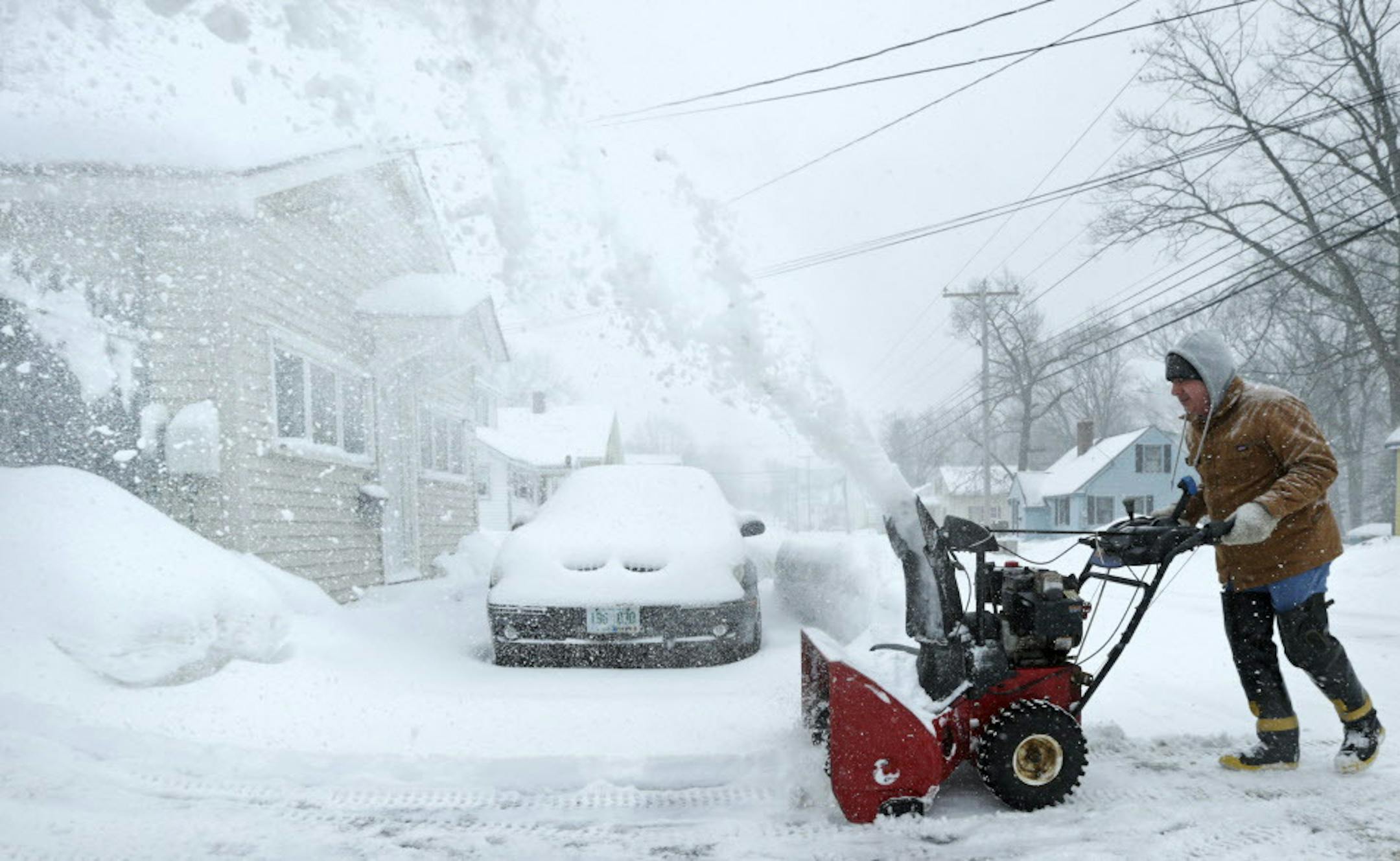 A man clears his driveway of snow in Derry, N.H., Monday, Feb. 2, 2015. Southern New Hampshire, which was hit with over two feet of snow last week, is expected to receive as much as another foot and a half in a winter storm that stretches from Michigan to Maine. (AP Photo/Charles Krupa)