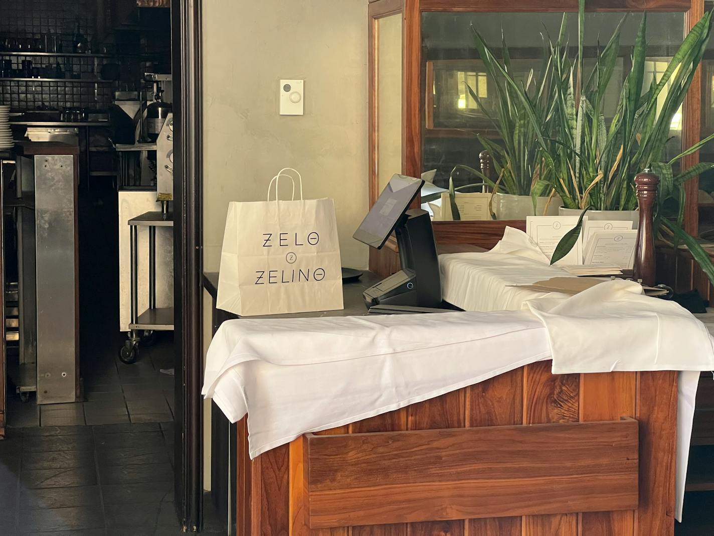 A Zelo takeout bag sits on a dust covered point of sale system.