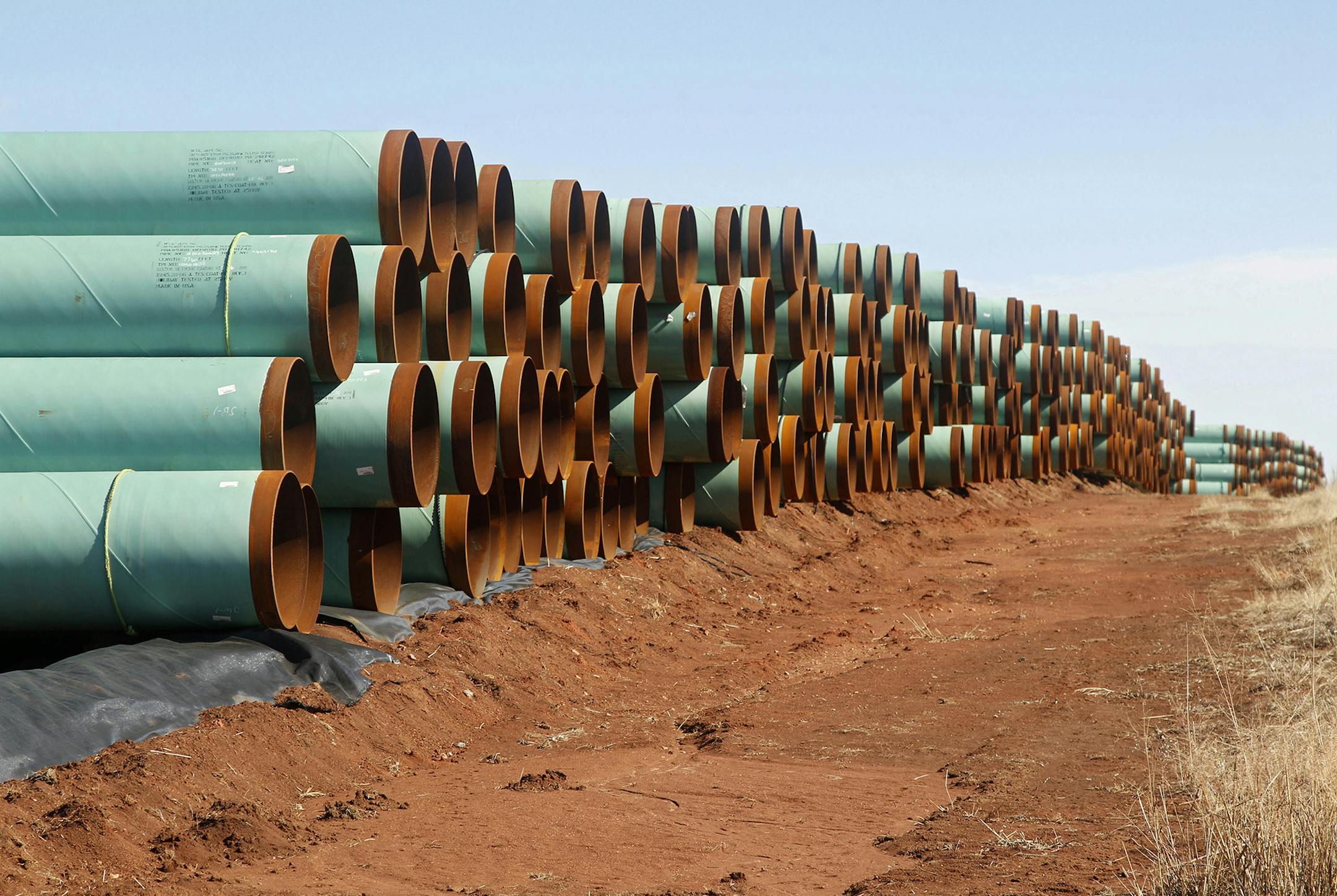 In this Feb. 1, 2012 file photo, miles of pipe ready to become part of the Keystone Pipeline are stacked in a field near Cushing, Okla.