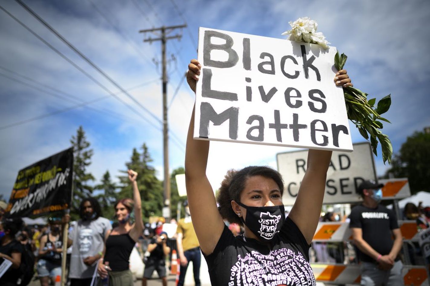 Trinity Dunlap, 15, of Maple Grove, held a Black Lives Matter sign over her head as she listened to Thursday's private memorial for George Floyd downtown. She says she wants to see justice and the abolishment and reformation of police.