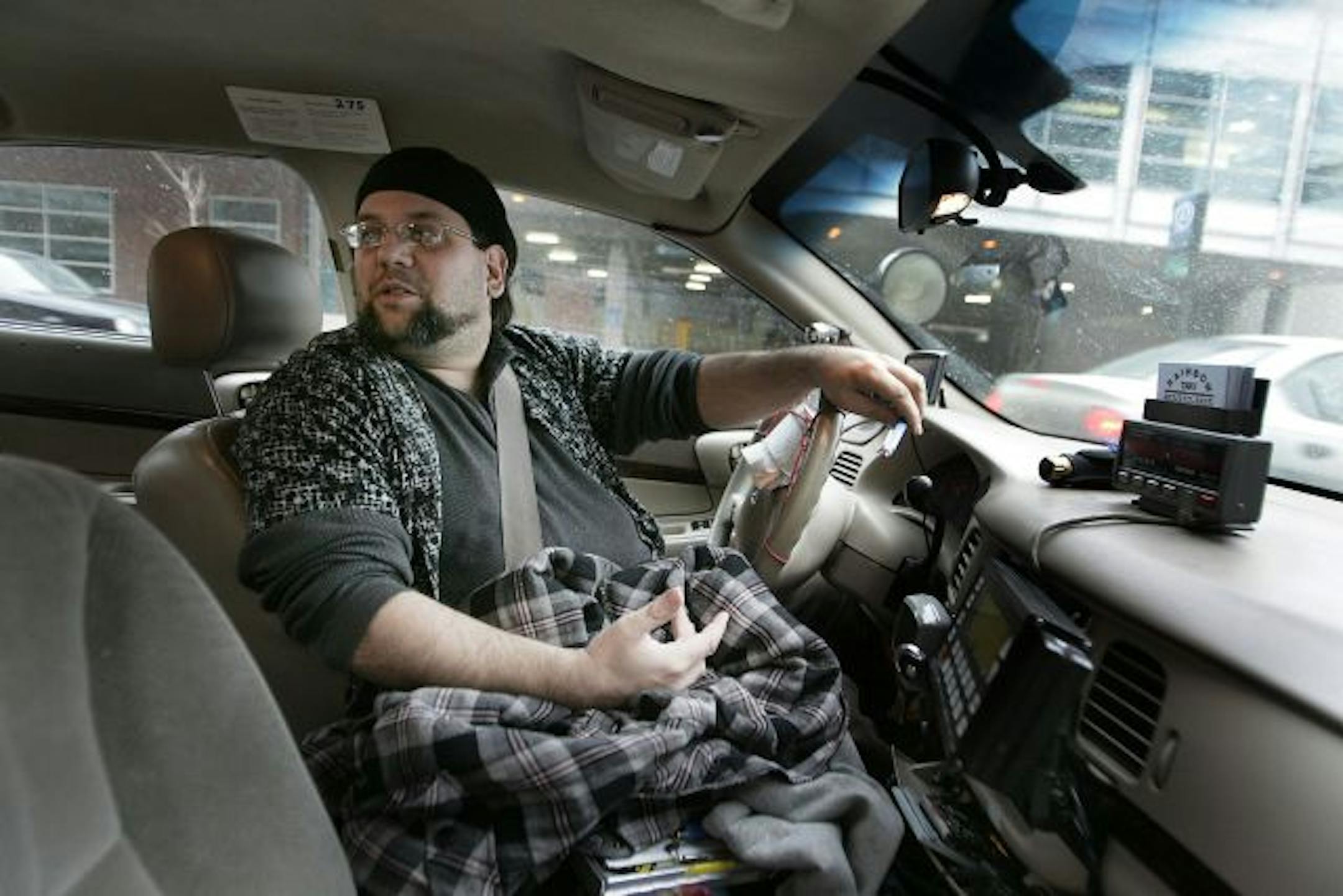 Rainbow Taxi driver Rufus Macgarnigle talked with fellow taxi driver Damon Cuccia as they waited for cutomers outside the Hilton Hotel in downtown Minneapolis.