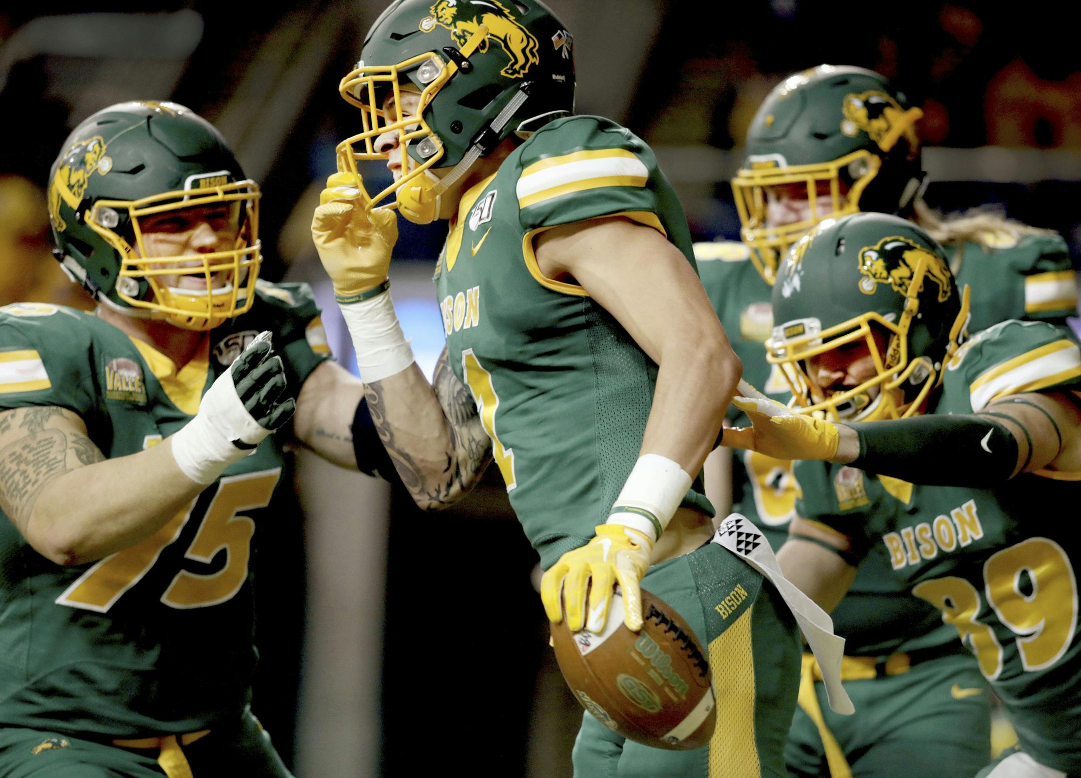 North Dakota State wide receiver Christian Watson, front, is mobbed by teammates after his long touchdown reception scores in the the first half of an FCS playoff NCAA college football game against Montana State, Saturday, Dec. 21, 2019, in Fargo, N.D. (AP Photo/Bruce Crummy)