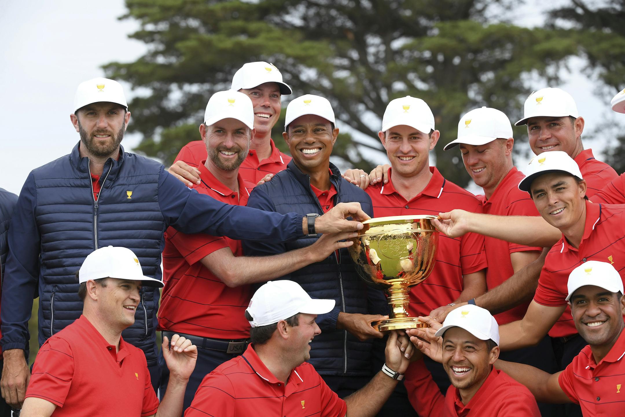 U.S. team player and captain Tiger Woods, center, holds the trophy with his players after the U.S. team won the President's Cup golf tournament at Royal Melbourne Golf Club in Melbourne, Sunday, Dec. 15, 2019. The U.S. team won the tournament 16-14. (AP Photo/Andy Brownbill)