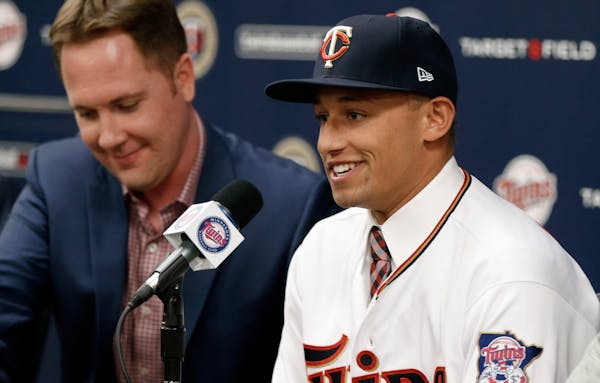 Twins Chief Baseball Officer Derek Falvey, left, listened as last year's first overall MLB draft pick, shortstop Royce Lewis, addressed the media in J