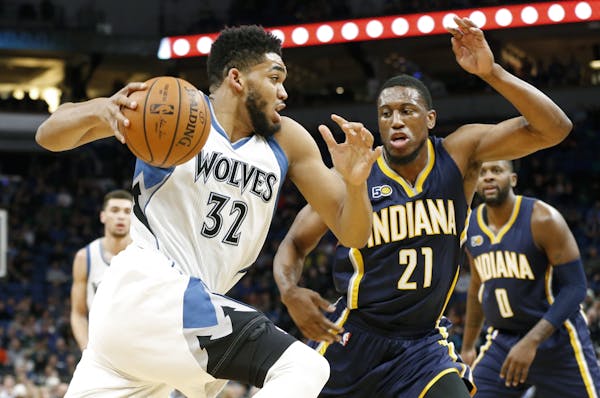 Minnesota Timberwolves' Karl-Anthony Towns, left, drives past Indiana Pacers' Thaddeus Young during the first quarter of an NBA basketball game Thursd