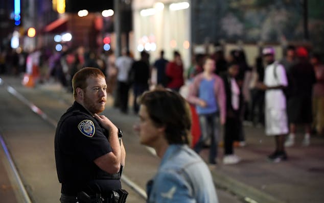 A police officer kept watch in downtown Minneapolis on a recent night after bar close along 5th Street near Hennepin Avenue — hot spots for trouble 