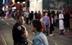 A police officer kept watch in downtown Minneapolis on a recent night after bar close along 5th Street near Hennepin Avenue — hot spots for trouble 
