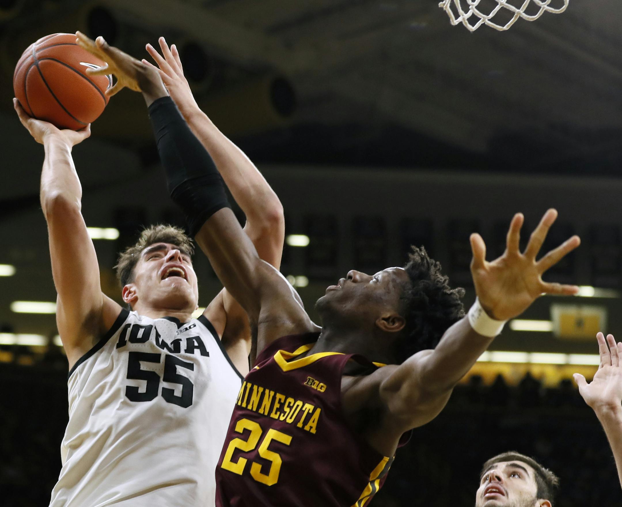 Iowa center Luka Garza shoots over Minnesota center Daniel Oturu (25) during the second half of an NCAA college basketball game, Monday, Dec. 9, 2019, in Iowa City, Iowa. Iowa won 72-52. (AP Photo/Charlie Neibergall)