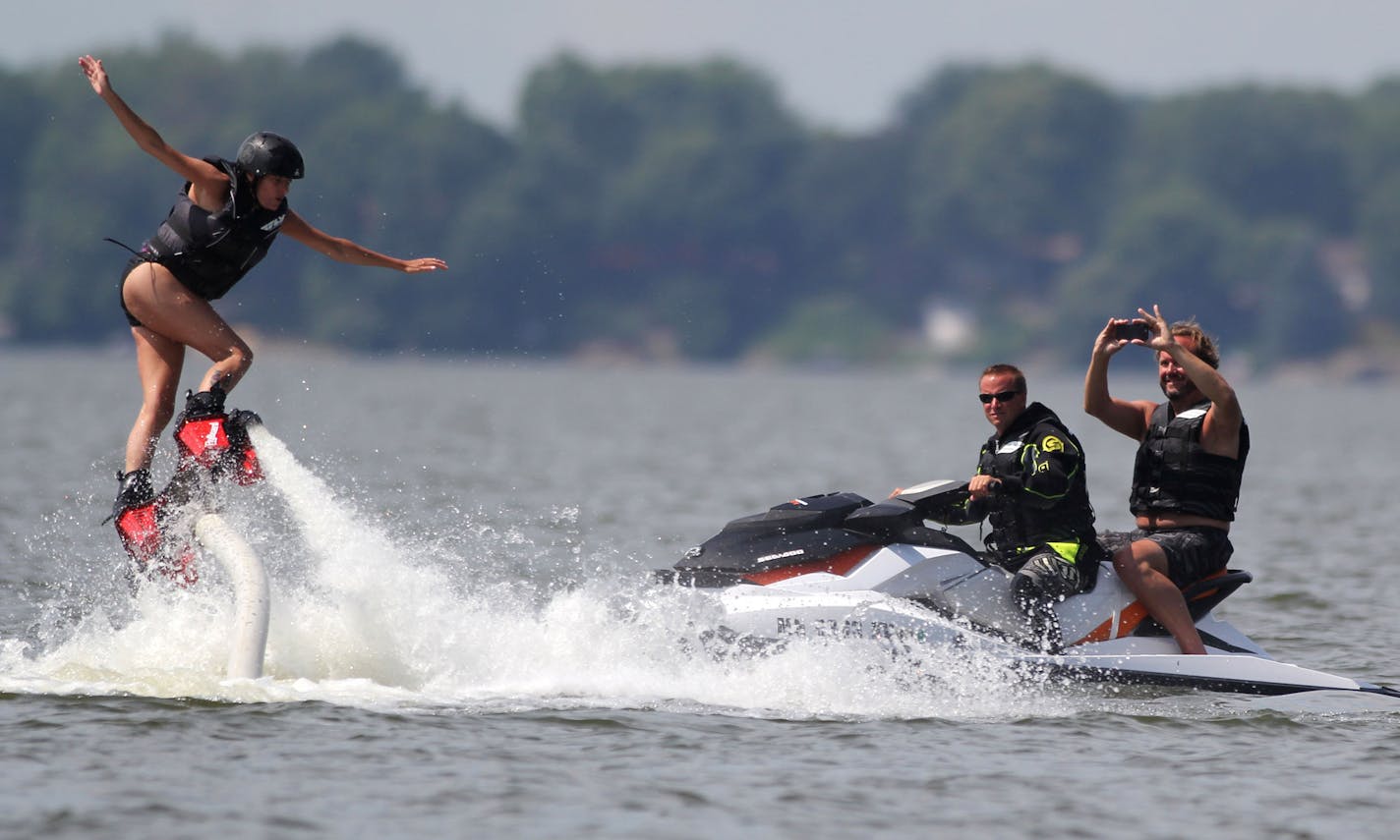 Holly Matzke (left) takes flyboarding lessons from Rodney Jansen (center) while Tom Garneau (ight) takes pictures, on Friday afternoon at Lake Waconia.] Rodney Jansen gave flyboarding lessons on Lake Waconia on Friday afternoon. Jansen started flyboarding three years ago, and started his rental company two years ago. His last weeks of summer will be busy as he is booked through the end of the season. MONICA HERNDON Waconia, MN 08/15/14