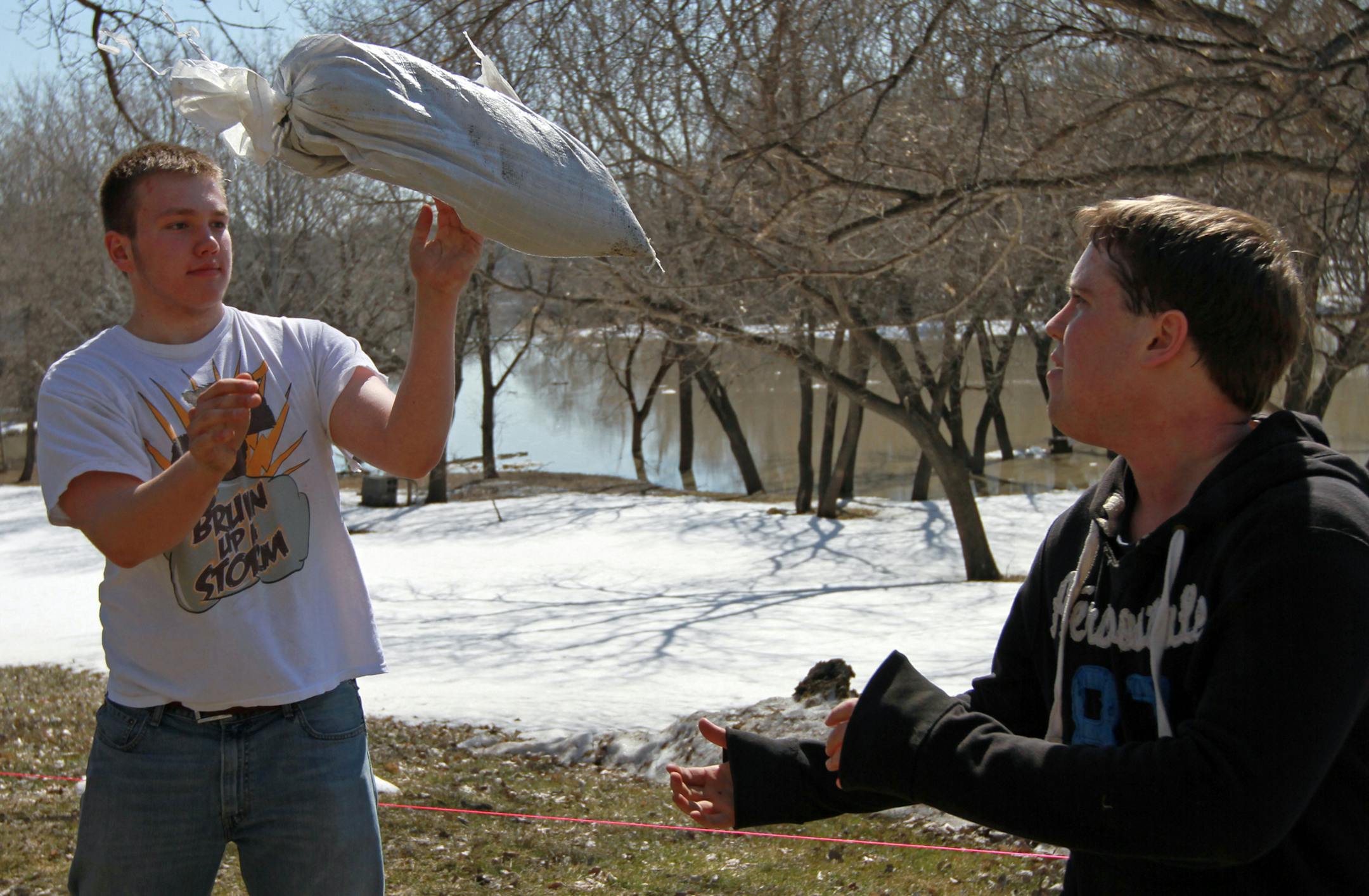 Fargo South High School students Reiey Donahue (left) and Nathen Christin volunteer to sandbag homes on River Drive South in Fargo, North Dakota Friday, April 26, 2013. Over 1,500 students were given the morning off from school and were bused to several areas to place over 100,000 sandbags which made over three miles of temporary levees. ] SHARI L. GROSS‚Ä¢ sgross@startribune.com