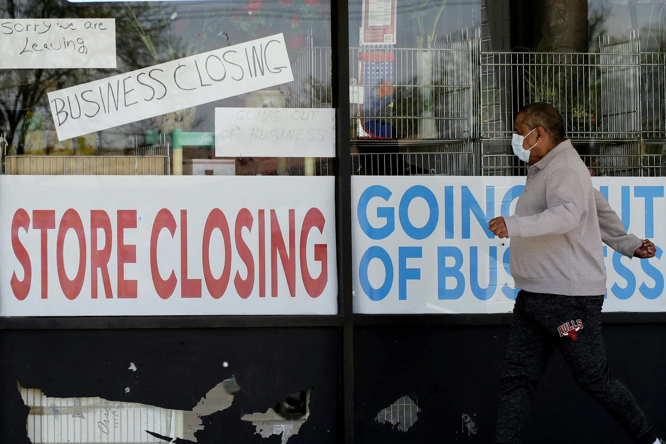 FILE - In this May 21, 2020 file photo, a man looks at signs of a closed store due to COVID-19 in Niles, Ill. U.S. businesses shed 2.76 million jobs in May, as the economic damage from the historically unrivaled coronavirus outbreak stretched into a third month. The payroll company ADP reported Wednesday that businesses have let go of a combined 22.6 million jobs since March.AP Photo/Nam Y. Huh, File)
