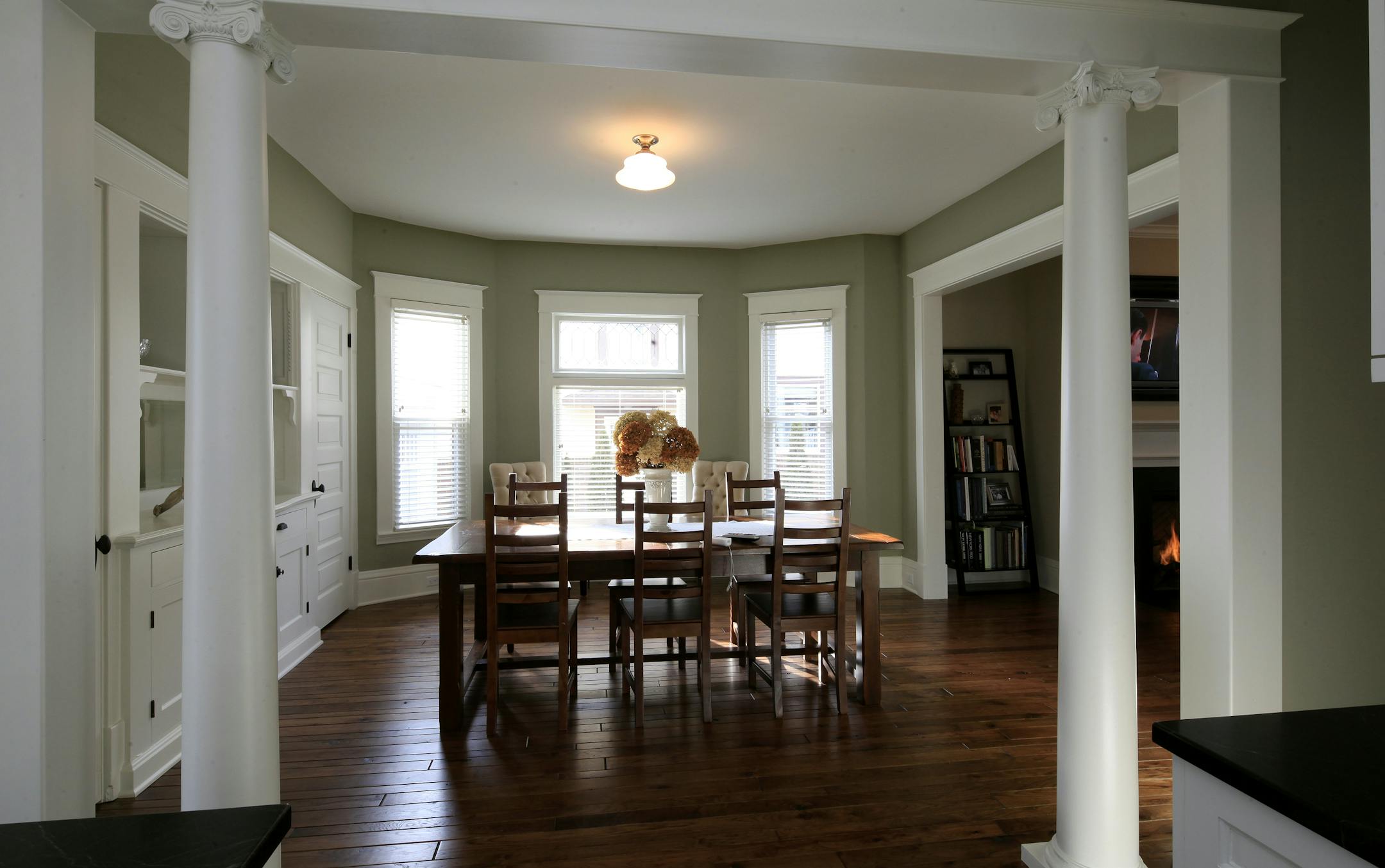 Architect Leah Ryan opened up the floor plan of her century-old home in Minneapolis to better accommodate modern living. Salvaged columns help to define the space.