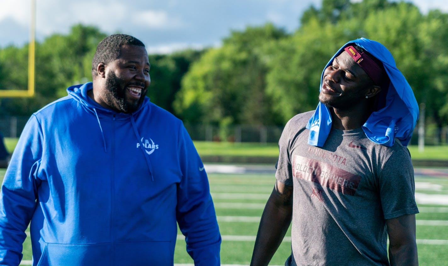 Polars head coach Charles Adams and Johnson catch up while the squad practices. ] MARK VANCLEAVE ¥ Minnesota Gophers wide receiver Tyler Johnson watched the Minneapolis North high school football team practice against other area teams during a scrimmage at Robbinsdale Cooper High School in New Hope on Wednesday, Jul 10, 2019.