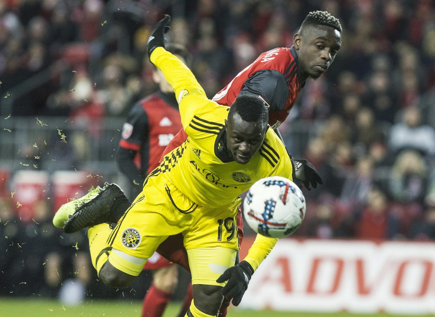 Columbus Crew forward Kekuta Manneh (19) is muscled off the ball by Toronto FC defender Chris Mavinga (23) during the second half of an Eastern Conference MLS final playoff soccer game, Wednesday, Nov. 29, 2017 in Toronto. (Chris Young/The Canadian Press via AP)