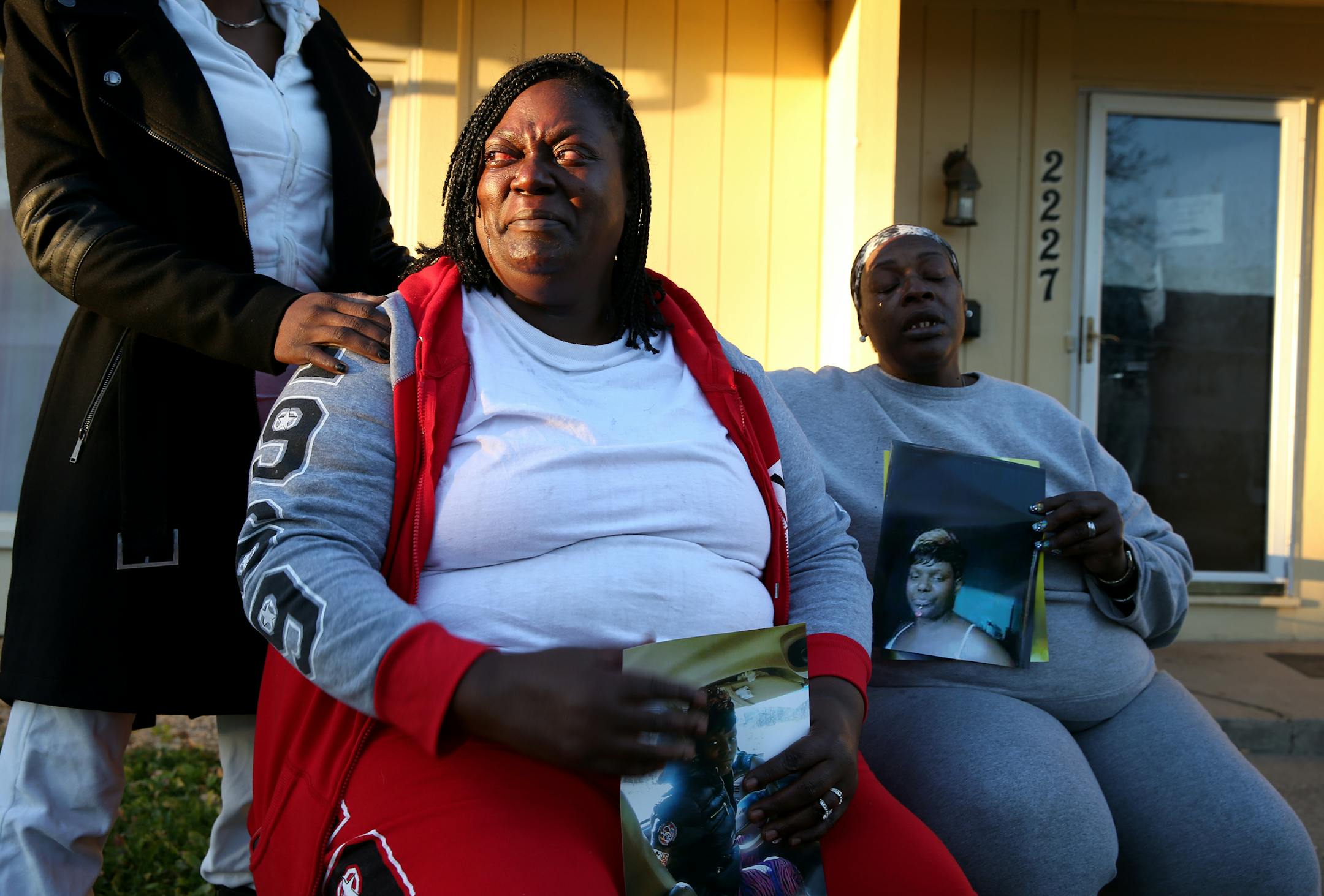 Gloria Cullom, the mother of Teaira Batey, one of the alleged victims of the serial killer Darren Deon Vann, cries while holding a photo of her daughter while sitting with her sister Annette Fields, far right, outside the home of a relative in St. Paul, Minn. ] LEILA NAVIDI leila.navidi@startribune.com / BACKGROUND INFORMATION: Tuesday, October 21, 2014.