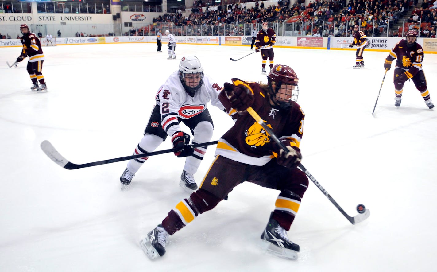 St. Cloud State's Jared Rabey and Minnesota-Duluth's Tim Smith chase the puck near the boards during the first period of a college hockey game Friday, March 2, 2012, in St. Cloud, Minn. (AP Photo/The St. Cloud Times, Dave Schwarz) NO SALES