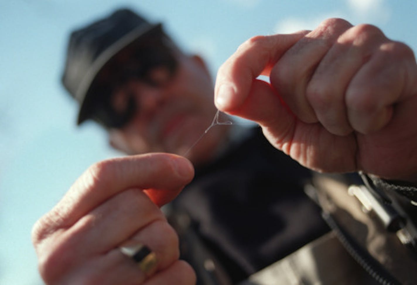 trout opener, which is saturday, april 17. featured will be tom helgeson, publisher of midwest fly fishing magazine, and a former mpls. star staffer. he and maybe one or two of his writers will be on the kinnikinnic river near river falls, wis.  -- Tom Helgeson, publisher of midwest fly fishing magazine ties knots in his fishing line by the Kinnikinnic river near River Falls, WI.