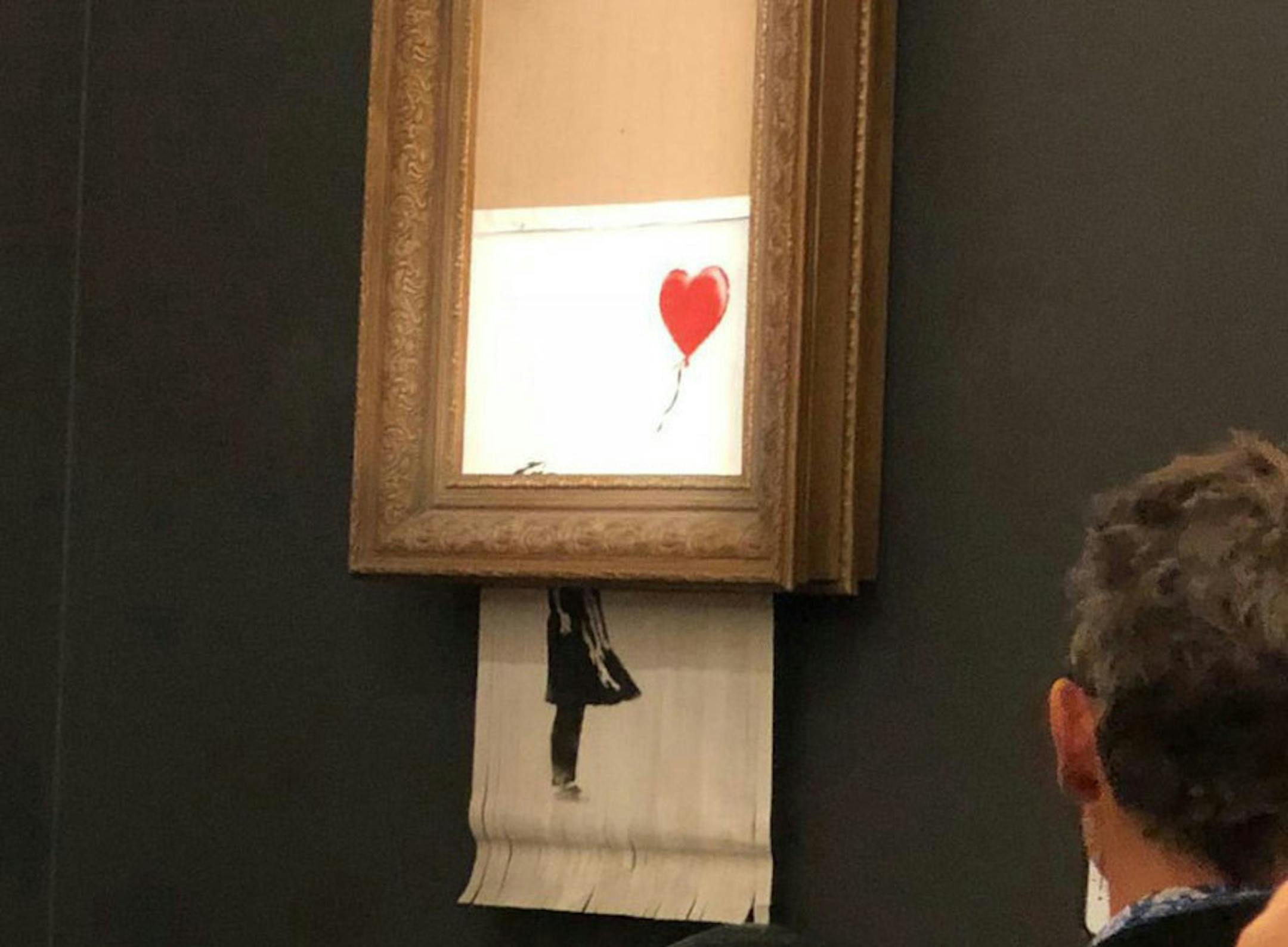 The moment when Banksy's "Girl with Balloon" was destroyed by a remote-control shredder.