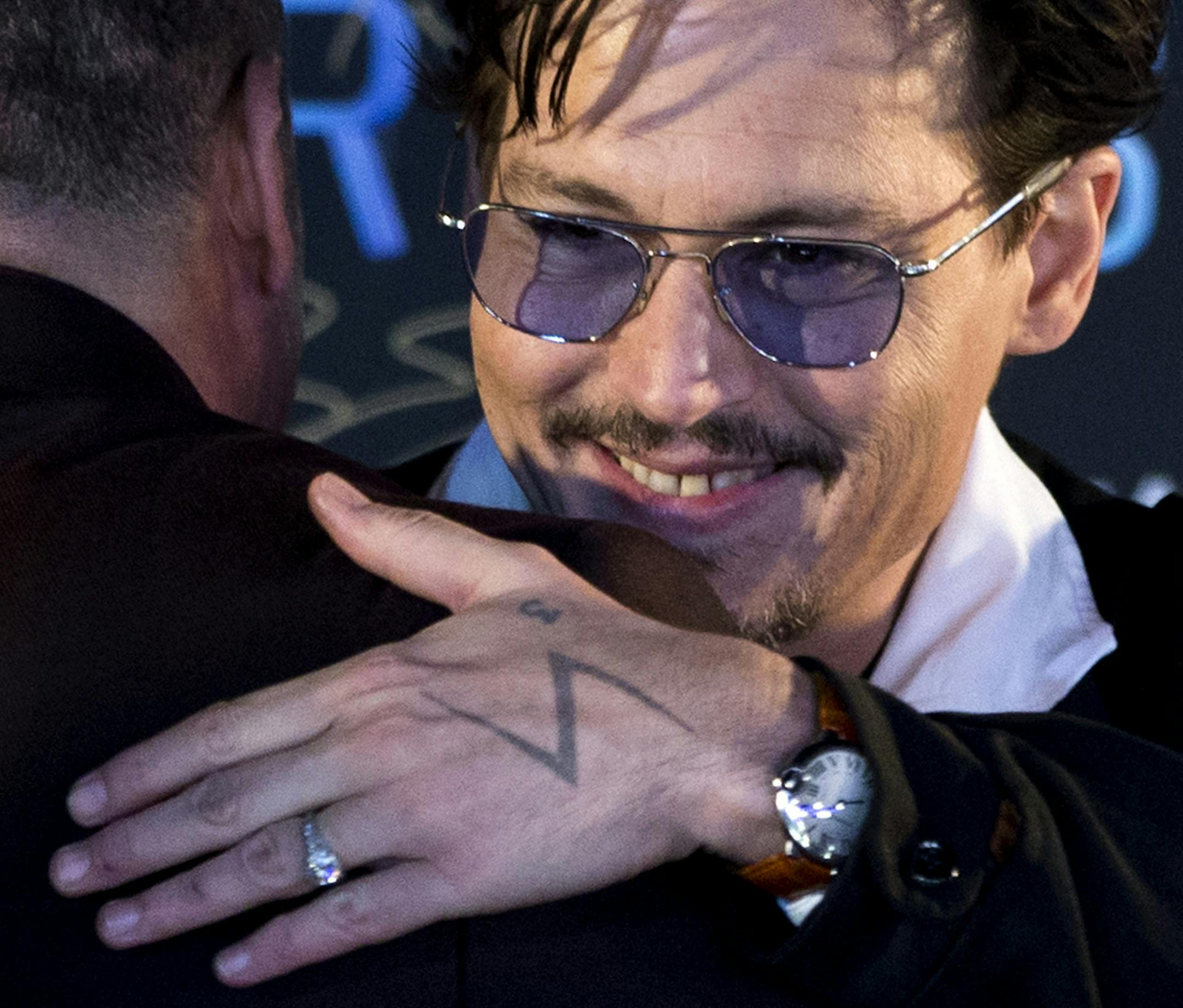 Actor Johnny Depp, with a diamond ring on his left hand, attends a promotional event for his new movie ìTranscendenceî in Beijing, China, Monday, March 31, 2014. Johnny Depp showed off a diamond engagement ring that he called a ìchickís ringî on Monday, indirectly confirming rumors of his engagement to actress Amber Heard. (AP Photo/Alexander F. Yuan)