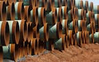 FILE - In this Feb. 1, 2012 file photo, miles of pipe for the stalled Canada-to-Texas Keystone XL pipeline are stacked in a field near Ripley, Okla. A