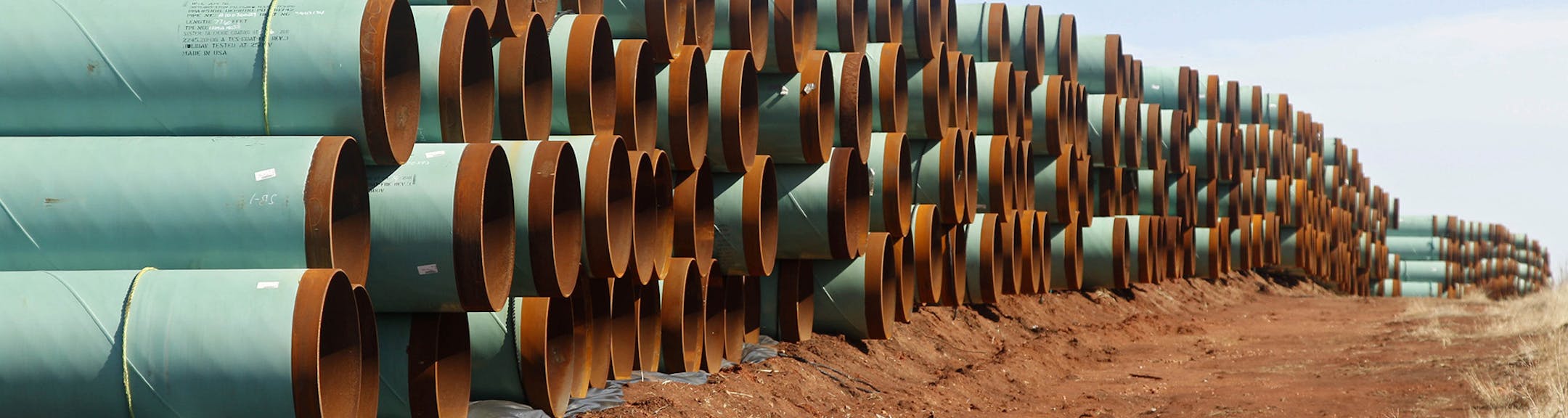 FILE - In this Feb. 1, 2012 file photo, miles of pipe for the stalled Canada-to-Texas Keystone XL pipeline are stacked in a field near Ripley, Okla. An Associated Press review of every cross-border pipeline application since 2004 shows that the Keystone review has been anything but ordinary. The company hoping to build Keystone has been waiting for a decision for nearly 7 years ó or more than five times the average. (AP Photo/Sue Ogrocki, File) ORG XMIT: MIN2015100514424030