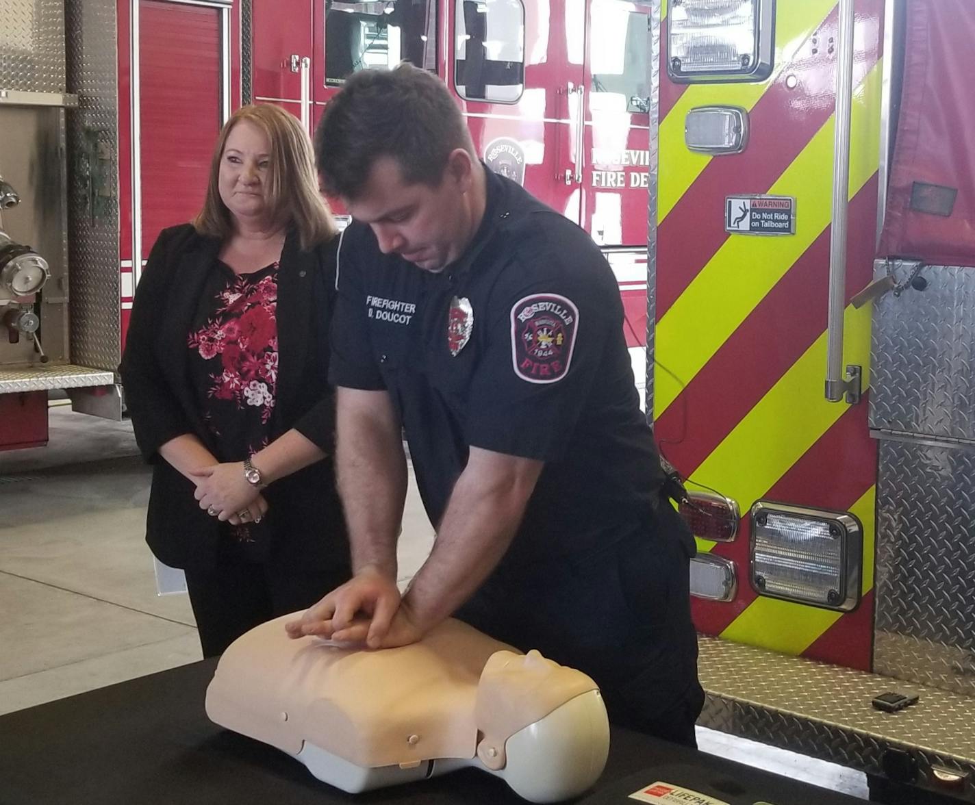 Roseville Firefigher Dave Doucet and Nancie Pass, a deputy director with Ramsey County Emergency Communications, takes turns demonstrating hands-on CPR at Roseville's fire station on Thursday. Shannon Prather, Star Tribune