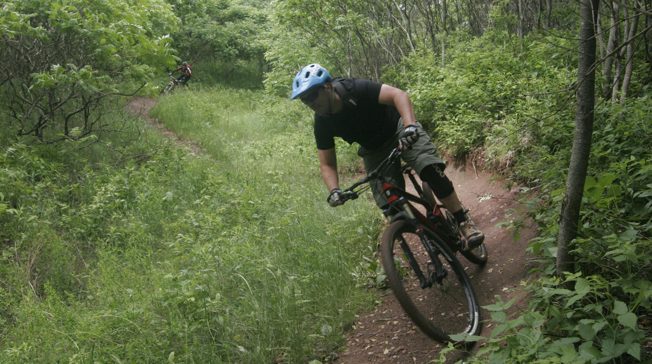 Aaron Hautala of Cuyuna, president of the Cuyuna Lakes Mountain Bike Crew, the local club, navigates a trail. Behind him is Jim McCarvill, 64, of Richfield.