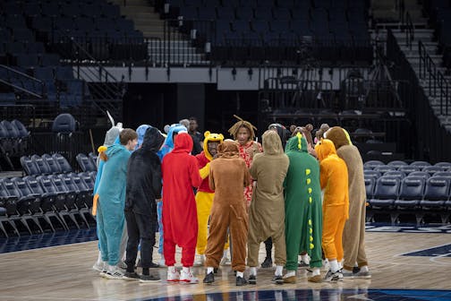 The Andover boys basketball team arrives on the court dressed in characters for a pep talk before they take on Park Center in the Class 4A basketball state tournament.