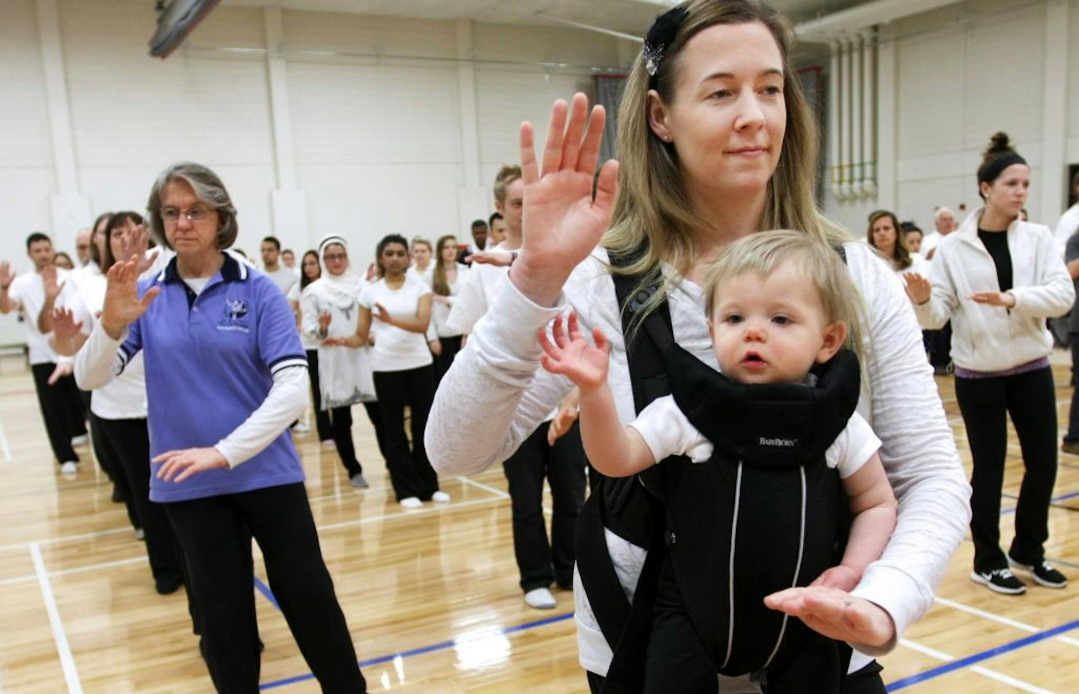 Bethany Nienhuis (cq/source) and her daughter Nya participate in the "Tai Chi for Arthritis Simplified Sun Style" demonstration. Nienhuis began as a tai chi student when she was pregnant and has continued to practice the form with her daughter.