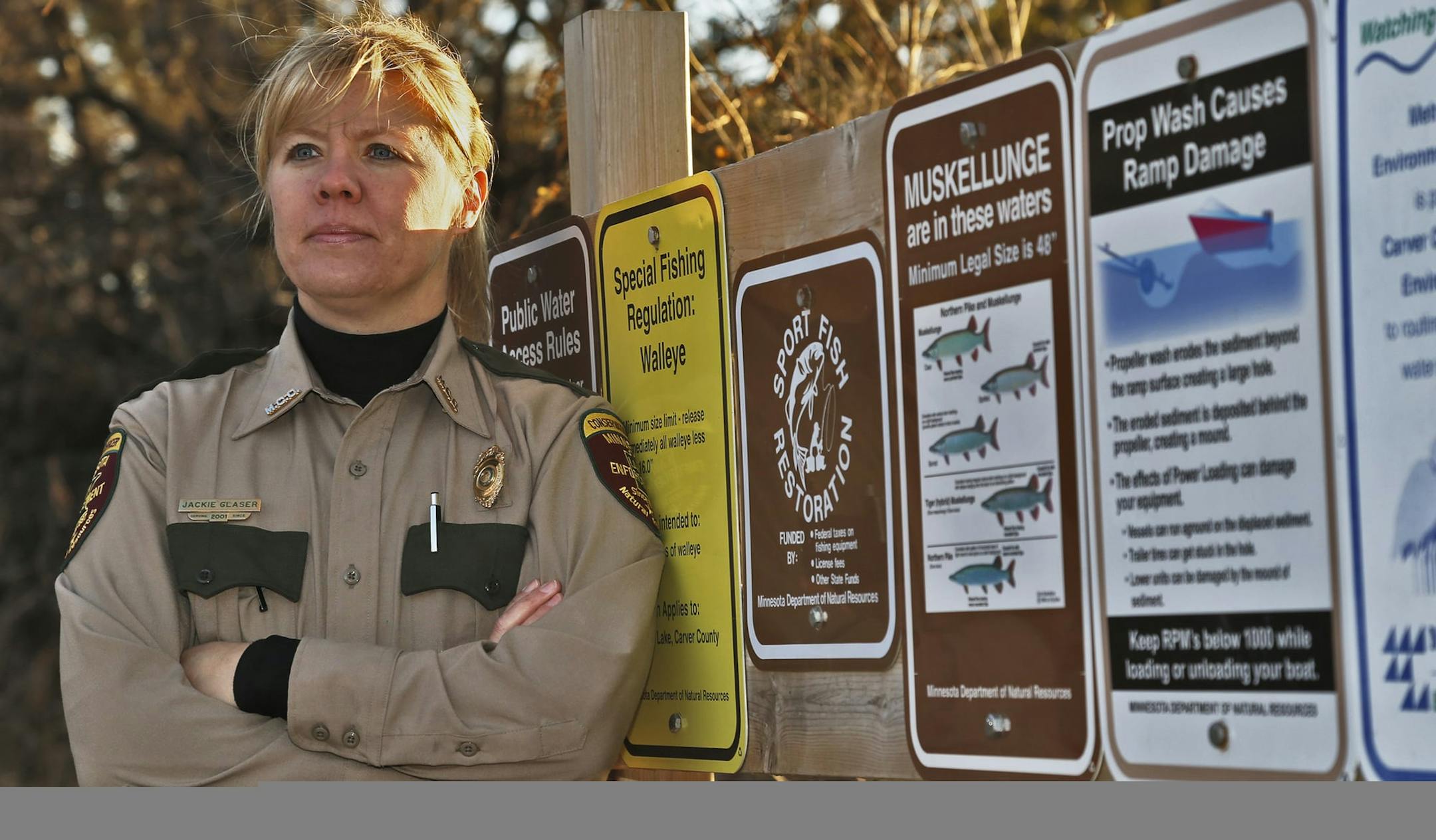 Jackie Glaser is a Minnesota DNR officer working on the west side of the Twin Cities. Glaser juggles her work duties with the responsibilities of being a mother of three young sons. Photos taken on the shore of Lake Waconia. Jackie Glaser in front of DNR information signs posted at public access. (MARLIN LEVISON/STARTRIBUNE(mlevison@startribune.com)