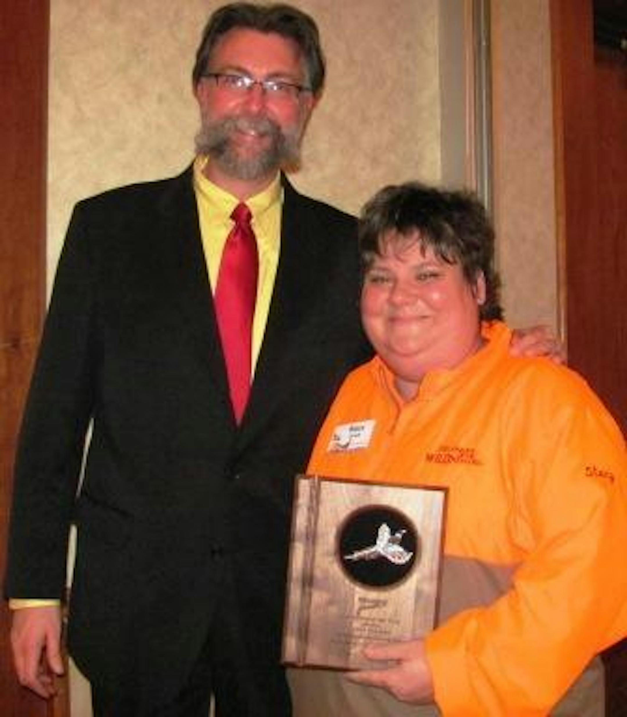 Stacy Dvorak receives the Minnesota Pheasants Forever Volunteer of the Year Award from Scott Roemhildt, Pheasants Forever Regional Representative.