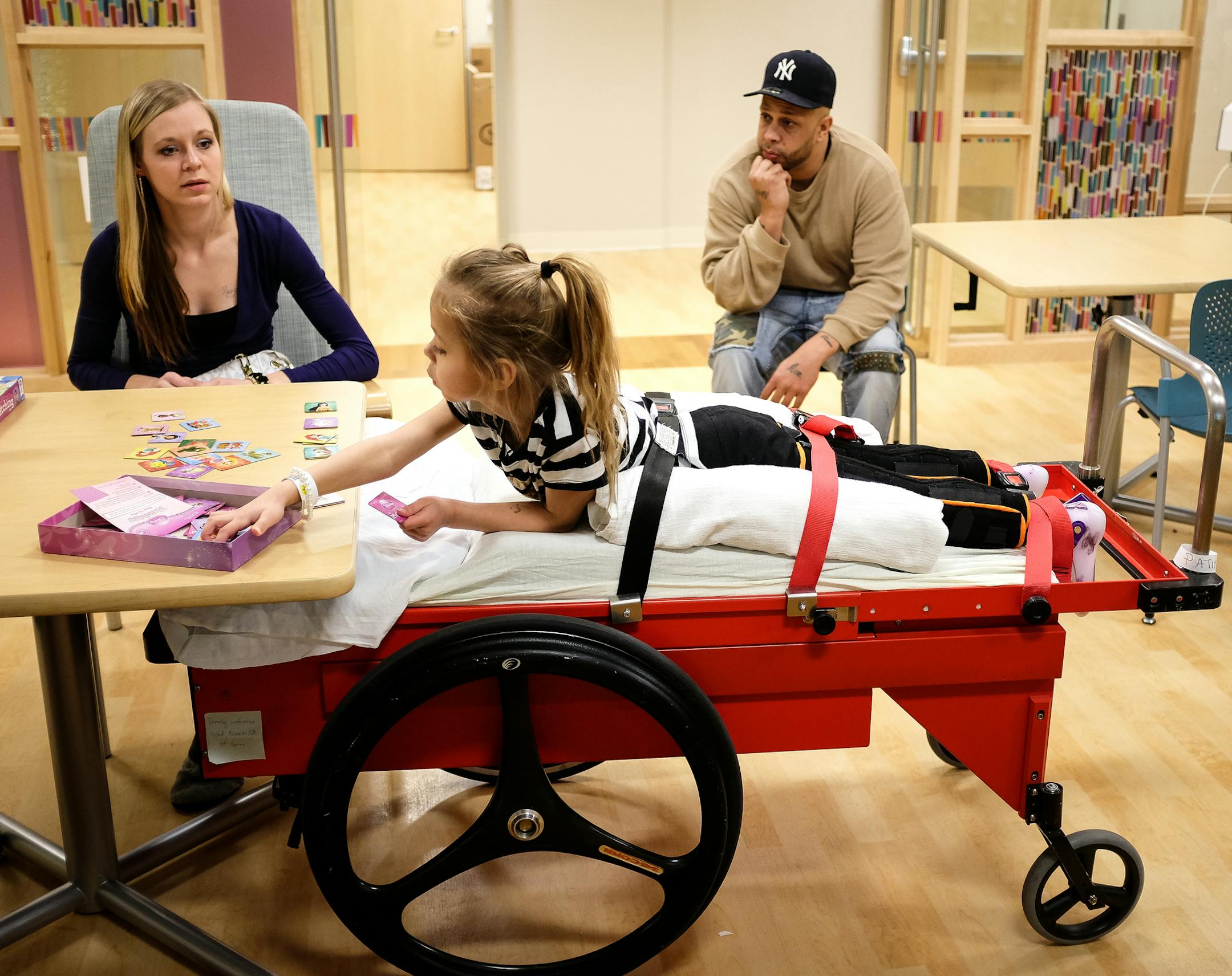 Patience Wheaton, 6, played a matching game with her mom, Bonnie Schehr, Wednesday at Gillette Children’s Hospital. Her dad, Kyle, watched the action.