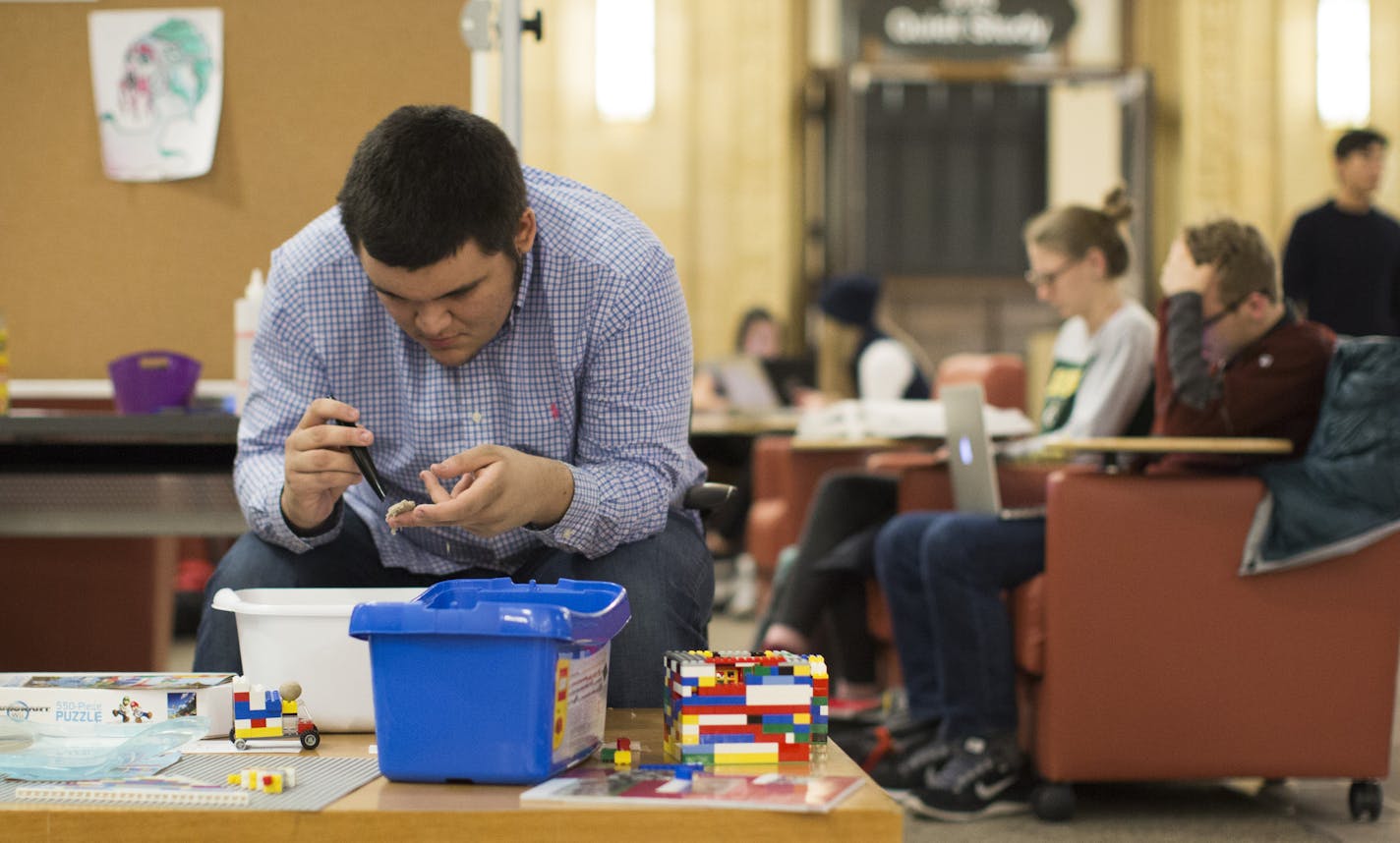 Sophmore Daniel Fabres took a break from studying for his his biogeography final by playing with moldable sand in a "relaxation room" at Walter Library at the University of Minnesota on Tuesday, December 15, 2015, in Minneapolis, Minn. ] RENEE JONES SCHNEIDER &#x2022; reneejones@startribune.com