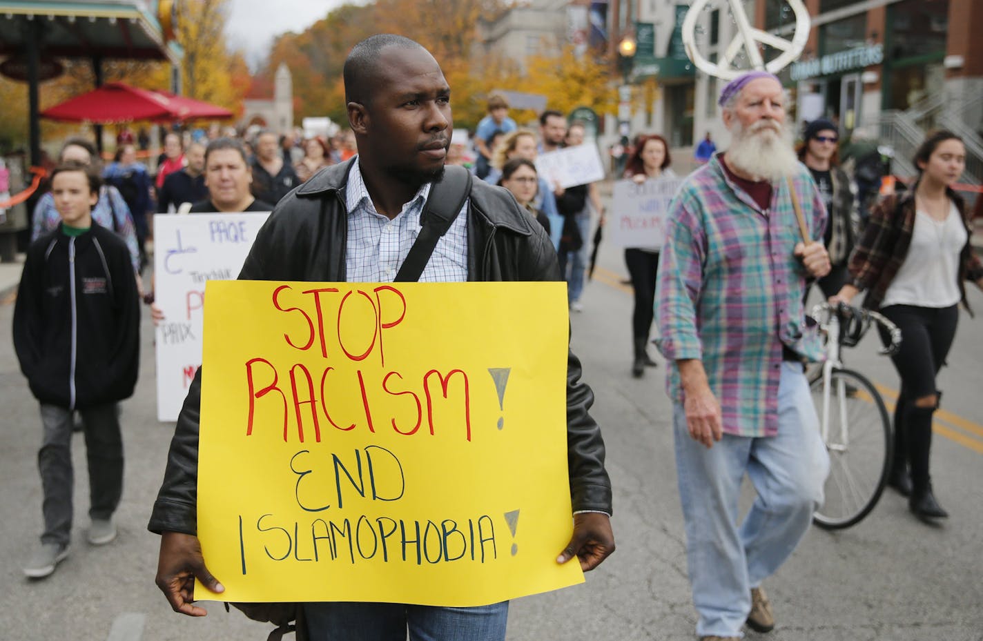 Khaled Esseissah carries a sign while marching against Islamophobia in Bloomington, Ind., Friday, Oct. 23, 2015. The march let to a rally at the Monroe County Courthouse in response to the Oct. 17 attack in which an Indiana University student shouted racial slurs and tried to remove a Muslim woman's headscarf. (Jeremy Hogan/The Bloomington Herald-Times via AP) ORG XMIT: MIN2015110212164420