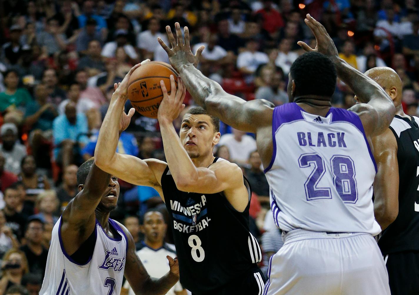 Minnesota Timberwolves� Zach LaVine (8) goes up for a shot against Los Angeles Lakers� Dwight Buycks, left, and Los Angeles Lakers� Tarik Black during the second half of their NBA summer league basketball game Friday, July 10, 2015, in Las Vegas. (AP Photo/John Locher)