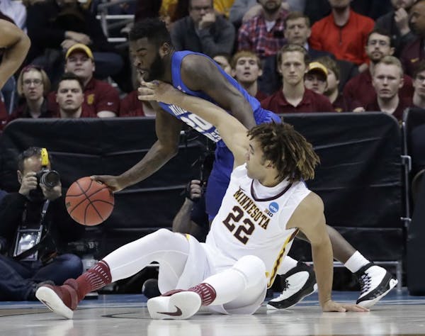 Middle Tennessee State's Giddy Potts (20) and Minnesota's Reggie Lynch battle for a loose ball early in the second half. Lynch picked up his third fou