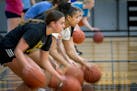 The New London-Spicer girls basketball team takes to the court for drills during practice in New London, Minn., in February.