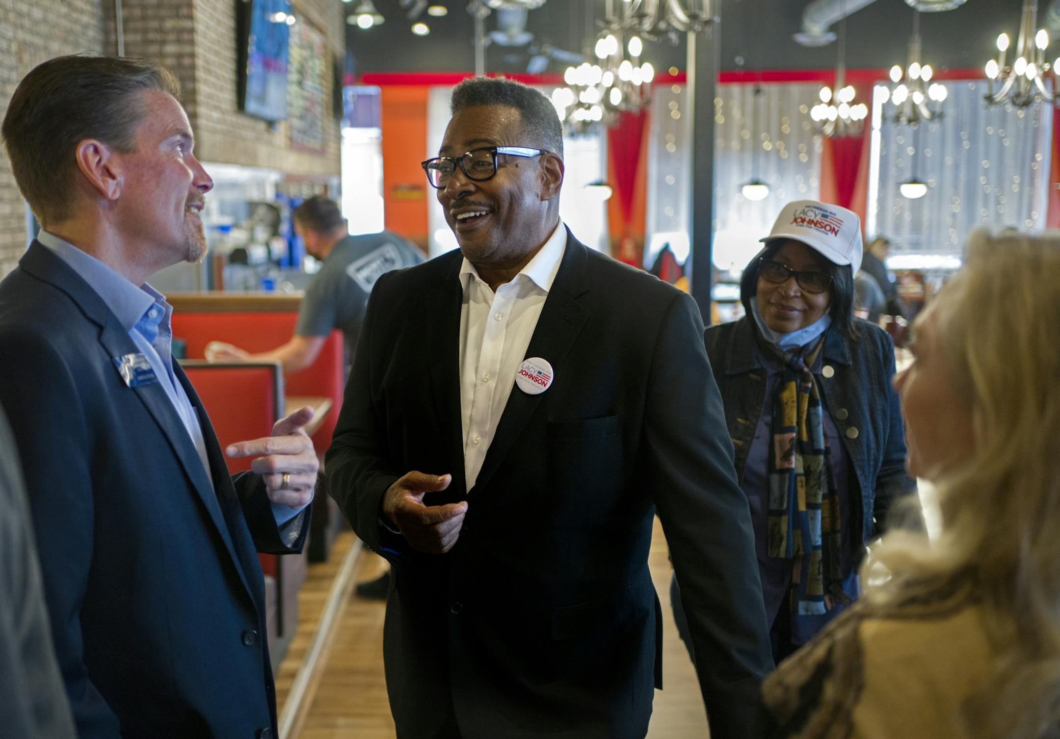 Republican Lacy Johnson, is using a large campaign war chest to woo new voters to the GOP side. While a victory is a longshot, his team hopes they can make inroads to narrow the gap for Trump statewide. Here, Lacy Johnson (center) chats with Minnesota Senator Mark Koran of District 32.