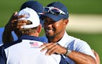 USA's Tiger Woods hugged J.B. Holmes on the 18th fairway after the USA's victory over Europe in the Ryder Cup Sunday.