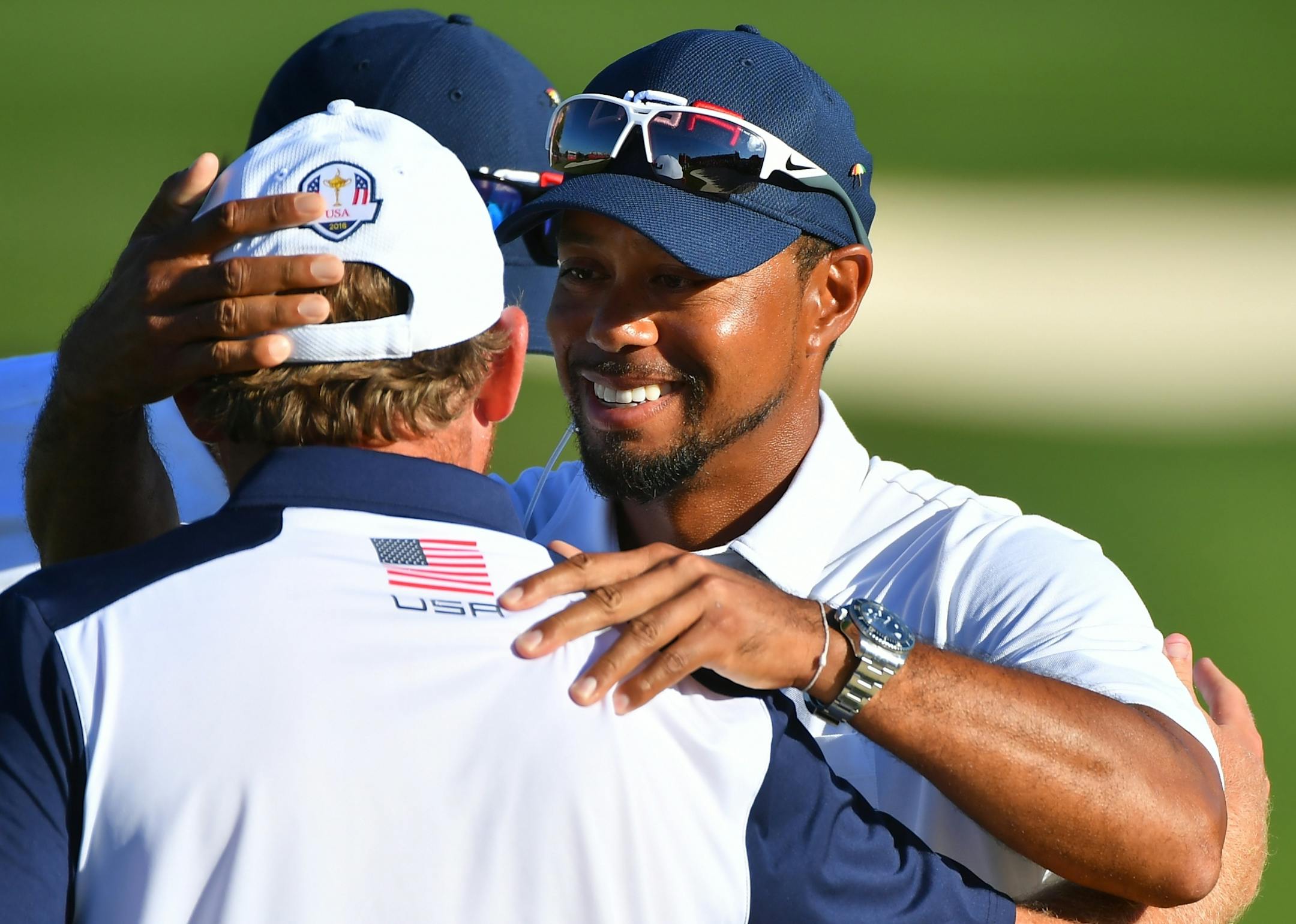 USA's Tiger Woods hugged J.B. Holmes on the 18th fairway after the USA's victory over Europe in the Ryder Cup Sunday.