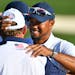 USA's Tiger Woods hugged J.B. Holmes on the 18th fairway after the USA's victory over Europe in the Ryder Cup Sunday.