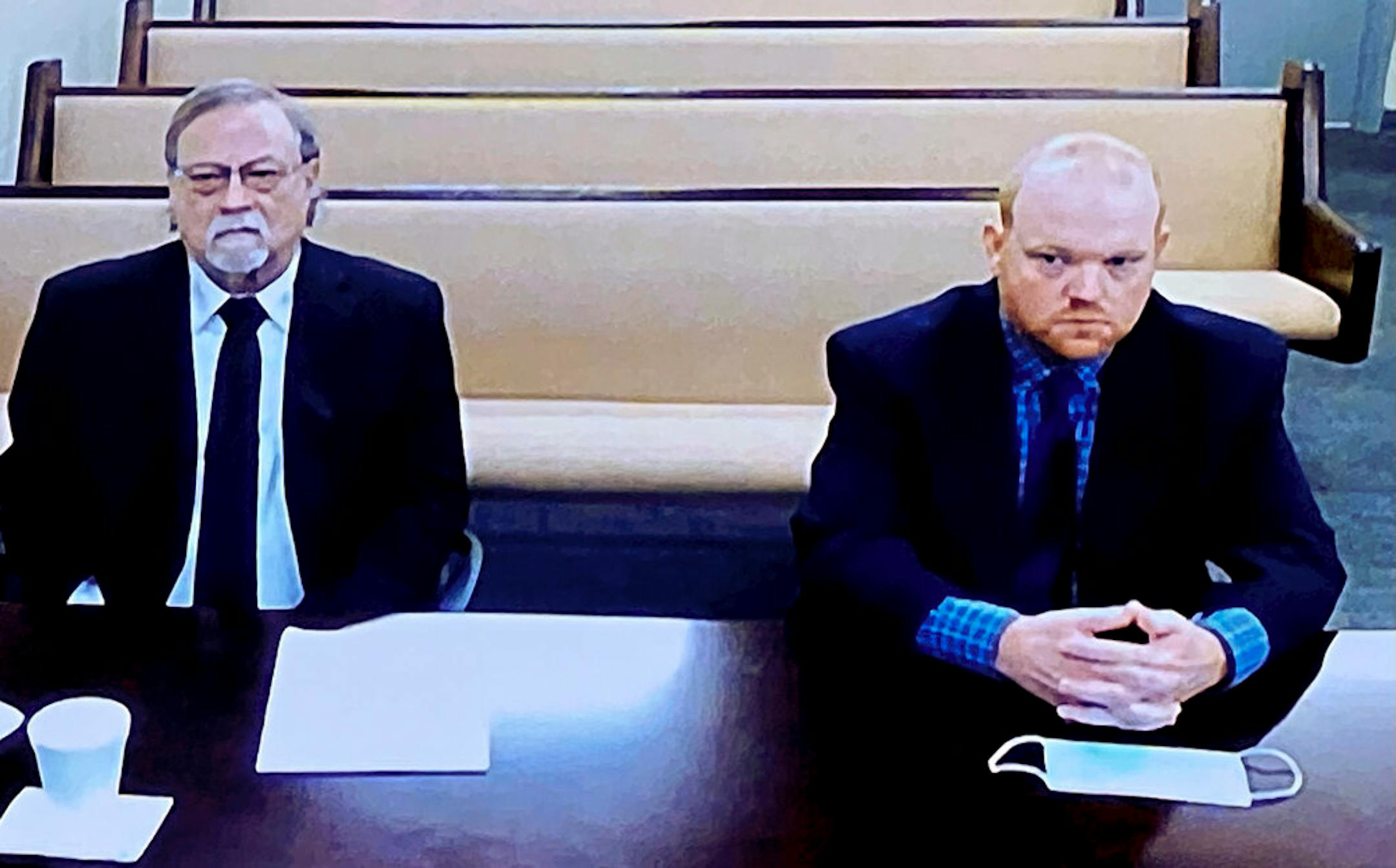 In this image made from video, Gregory and Travis McMichael, accused in the shooting death of Ahmaud Arbery, listened via closed circuit TV in the Glynn County Detention center in Brunswick, Ga., on Thursday, Nov. 12.