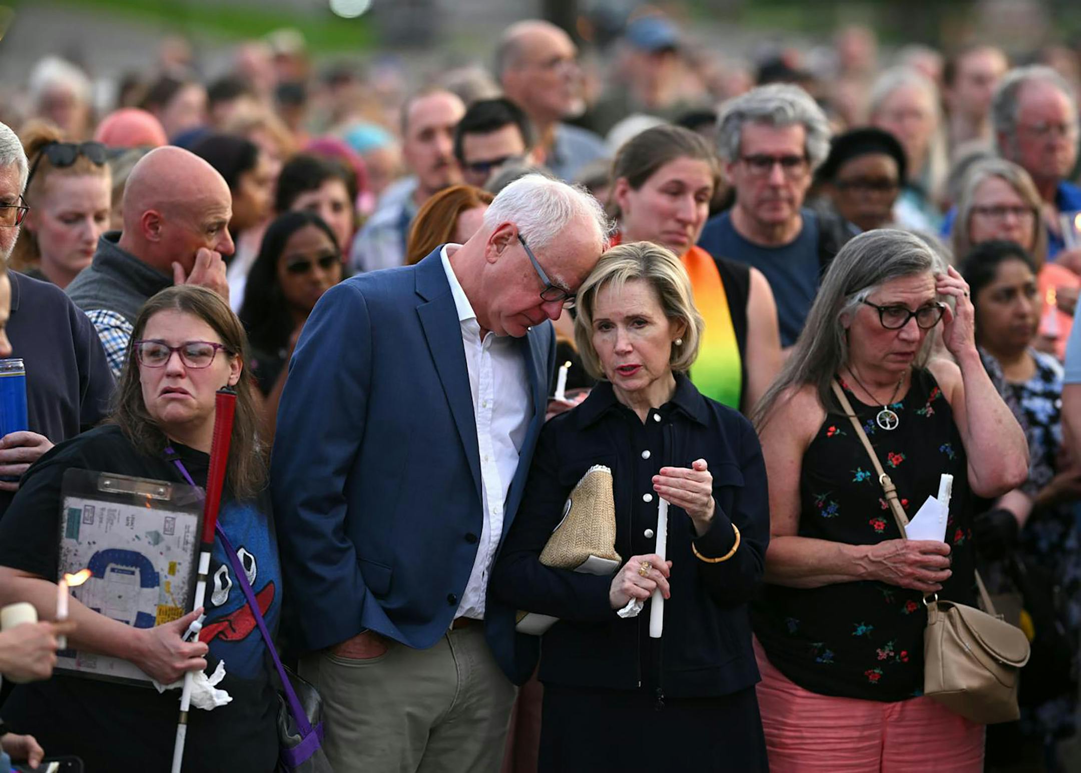 Gov. Tim Walz and his wife, Gwen, stand with the crowd during a candlelight vigil for Melissa and Mark Hortman at the State Capitol in St. Paul on Wednesday.