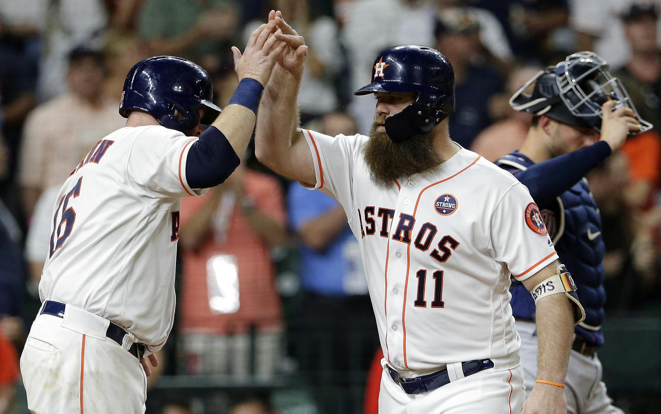 Houston Astros' Brian McCann (16) and Evan Gattis (11) celebrate at the plate, next to Minnesota Twins catcher Mitch Garver (23), after they scored on a two-run home run by Gattis during the fourth inning of a baseball game Wednesday Sept. 5, 2018, in Houston. (AP Photo/Michael Wyke)