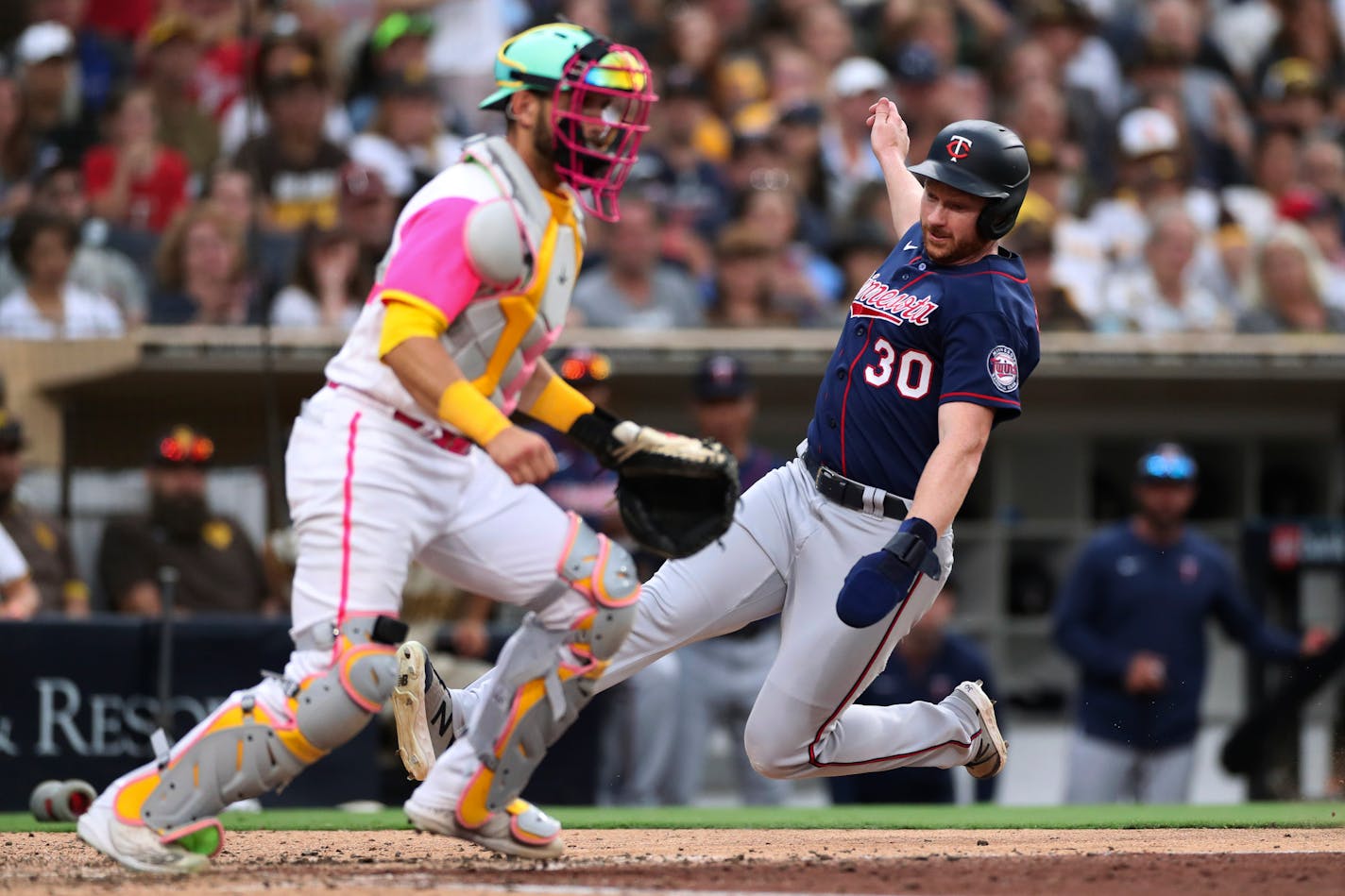 The Twins' Kyle Garlick scores on a single by Jose Miranda as San Diego catcher Austin Nola waits for the throw during the eighth inning Saturday