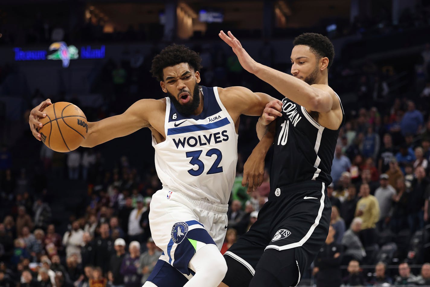 Minnesota Timberwolves center Karl-Anthony Towns (32) handles the ball against Brooklyn Nets guard Ben Simmons (10) during the first half of a preseason NBA basketball game Friday, Oct. 14, 2022, in Minneapolis. (AP Photo/Stacy Bengs)