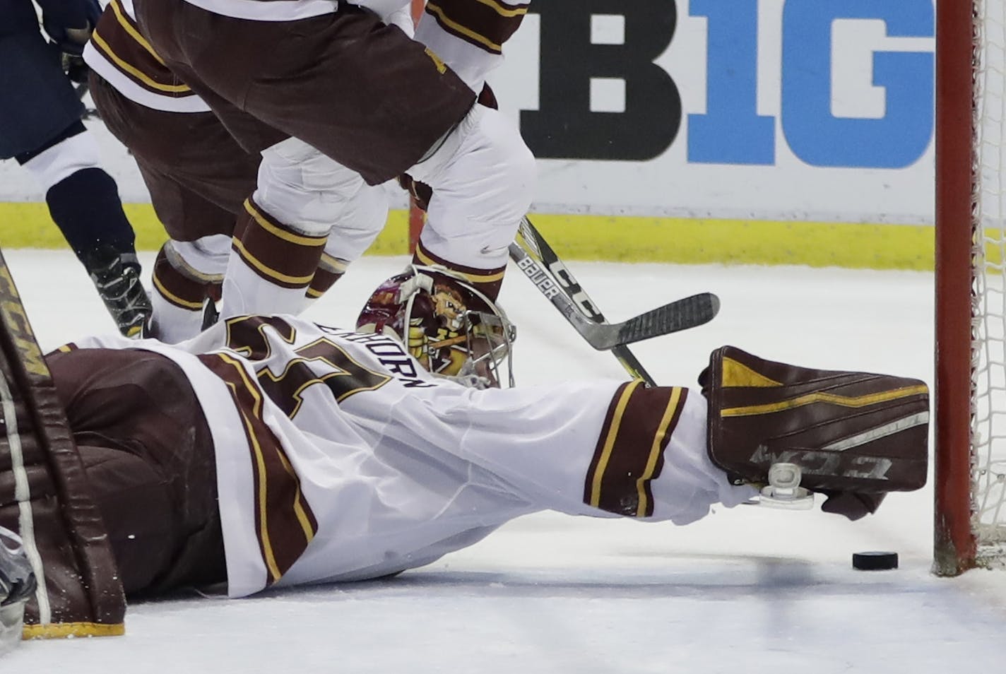 Minnesota goalie Eric Schierhorn reaches to stop the puck during the first period of an NCAA college hockey semifinal match against Penn State in the Big Ten Tournament, Friday, March 17, 2017, in Detroit. (AP Photo/Carlos Osorio)