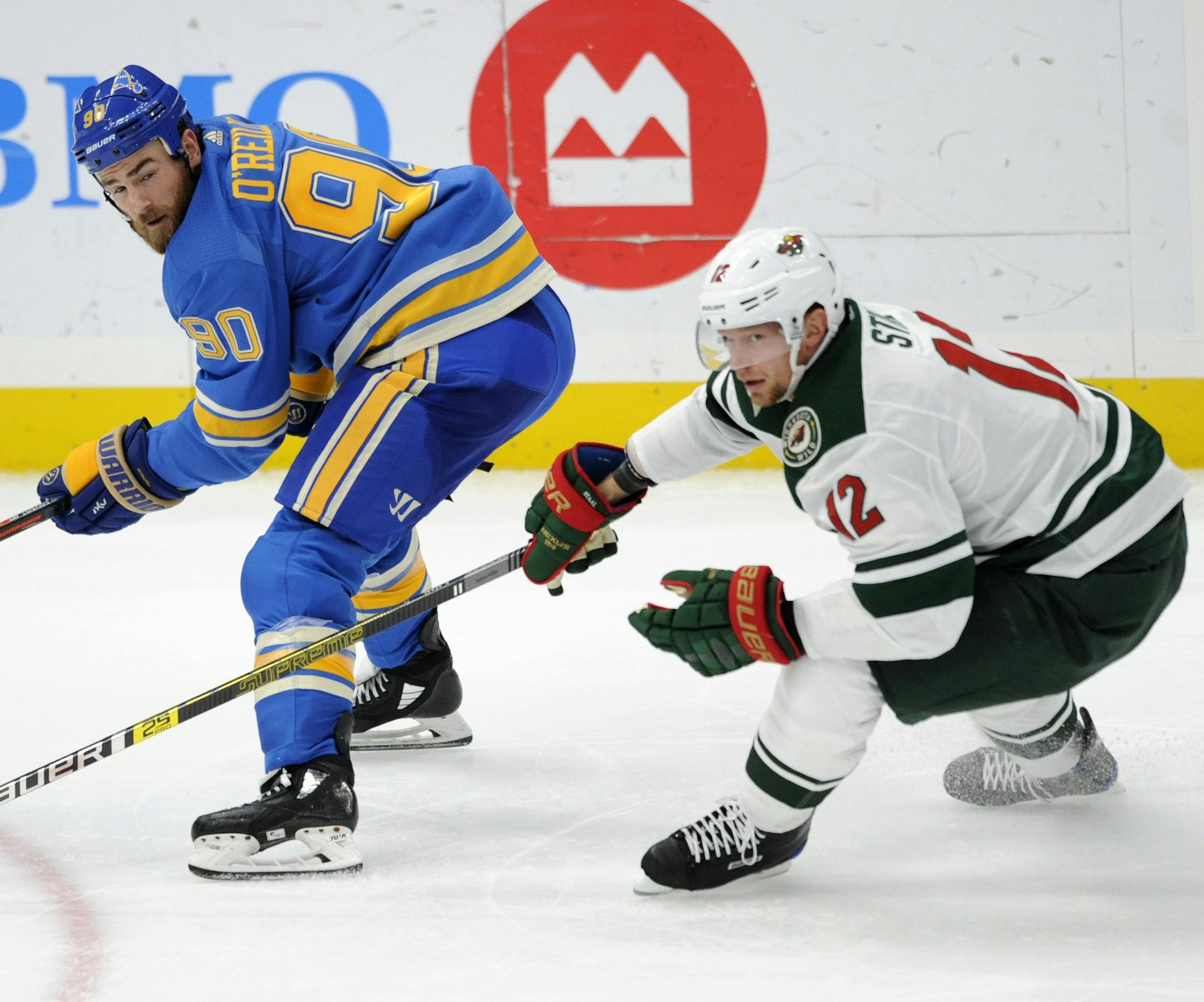 St. Louis Blues' Ryan O'Reilly (90) and Minnesota Wild's Eric Staal (12) look for the puck during the third period of an NHL hockey game, Saturday, Nov. 3, 2018, in St. Louis. (AP Photo/Bill Boyce)